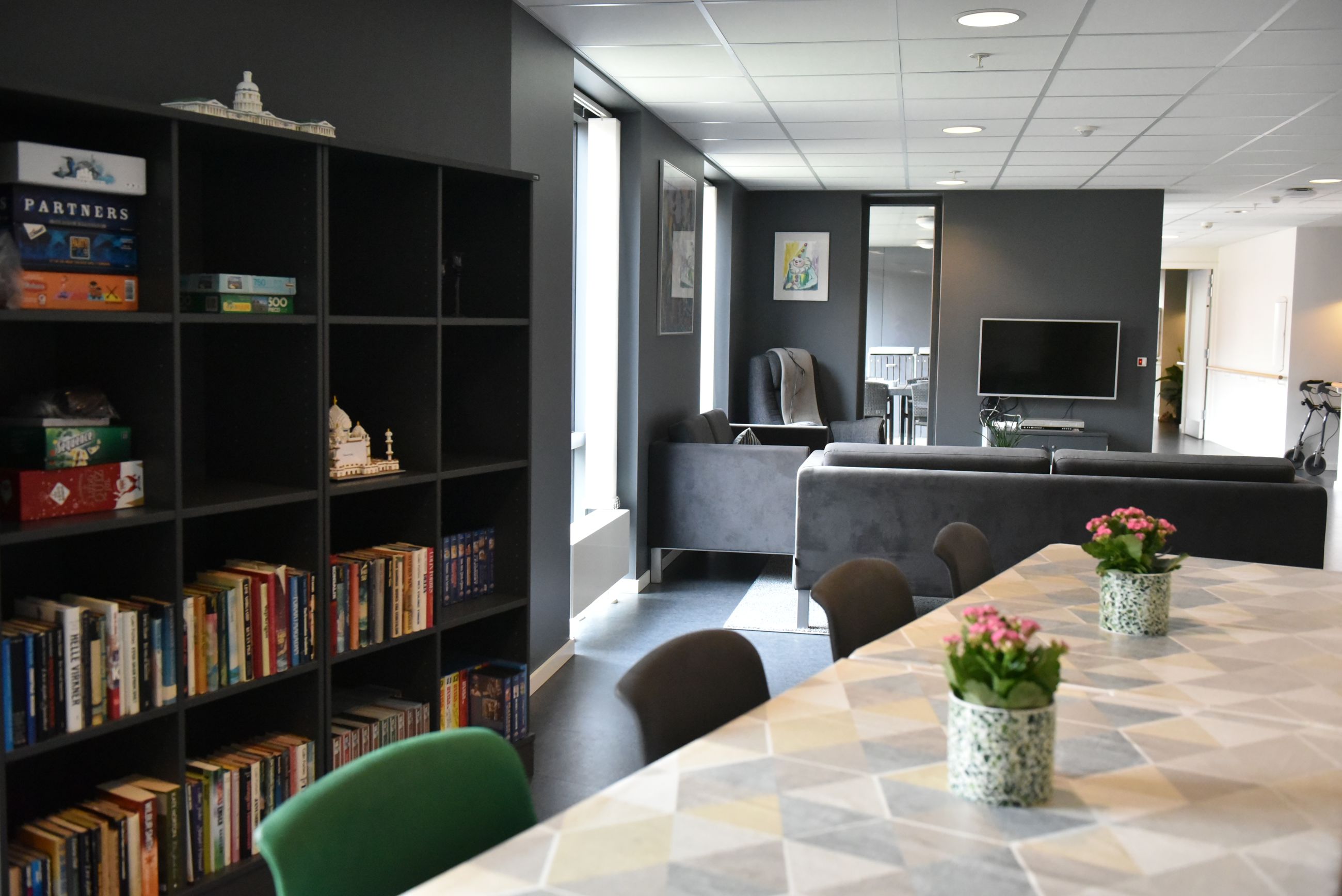 Opholdsrum med spisepladser, bogreol og tv-stue