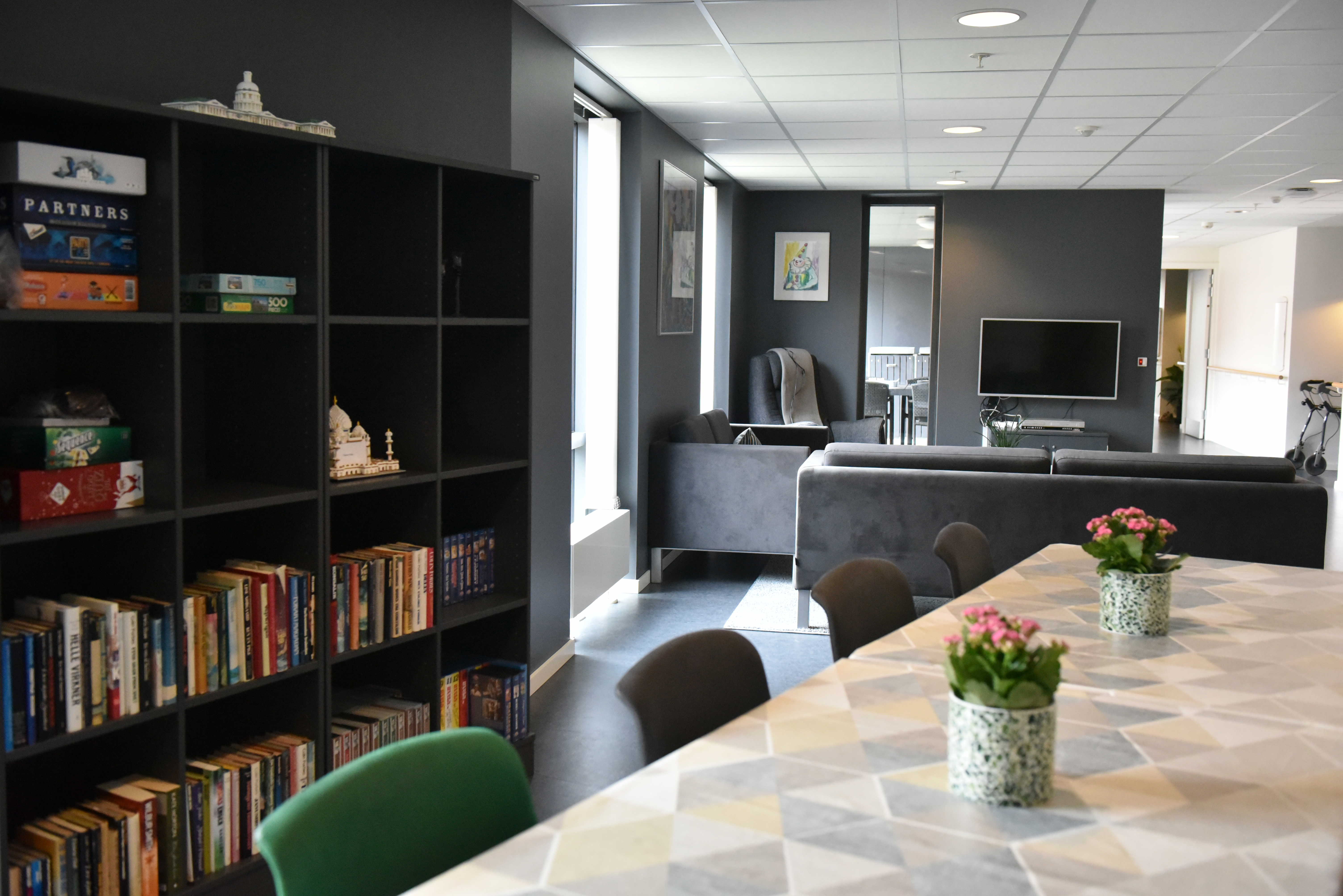 Opholdsrum med spisepladser, bogreol og tv-stue